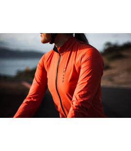 women water restistant cycling jacket brick red mirai pedaled in action